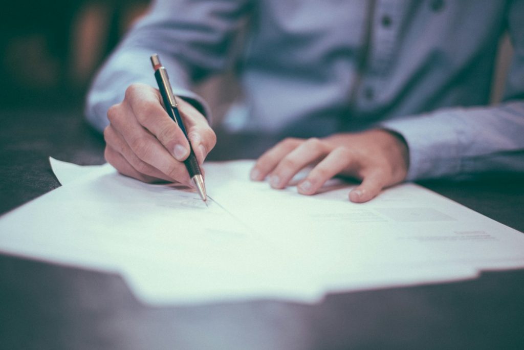 Accountant signing off documents with a pen